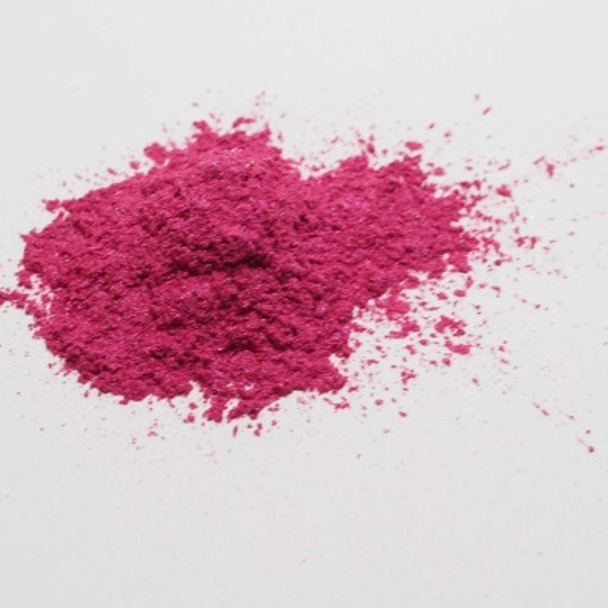 Häufchen pinkes Mica-Puder (Fantasia Pink) auf einer weißen Oberfläche